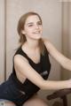 A young woman sitting on top of a wooden chair.