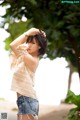 A woman in a striped top and denim shorts posing for a picture.