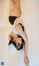 A woman laying on top of a bed wearing a nurse hat.