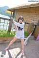 A woman standing on a wooden deck holding a gun.