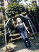 A woman sitting on a swing holding a bottle of water.