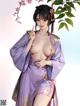 A woman in a purple kimono posing for the camera.