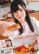 A woman sitting at a table with a plate of food.